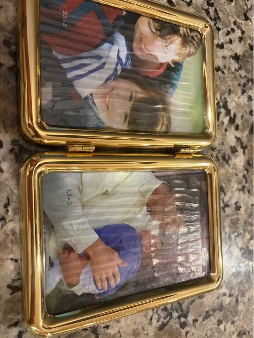 A contemporary Fetco brand gold-tone hinged double photo frame.